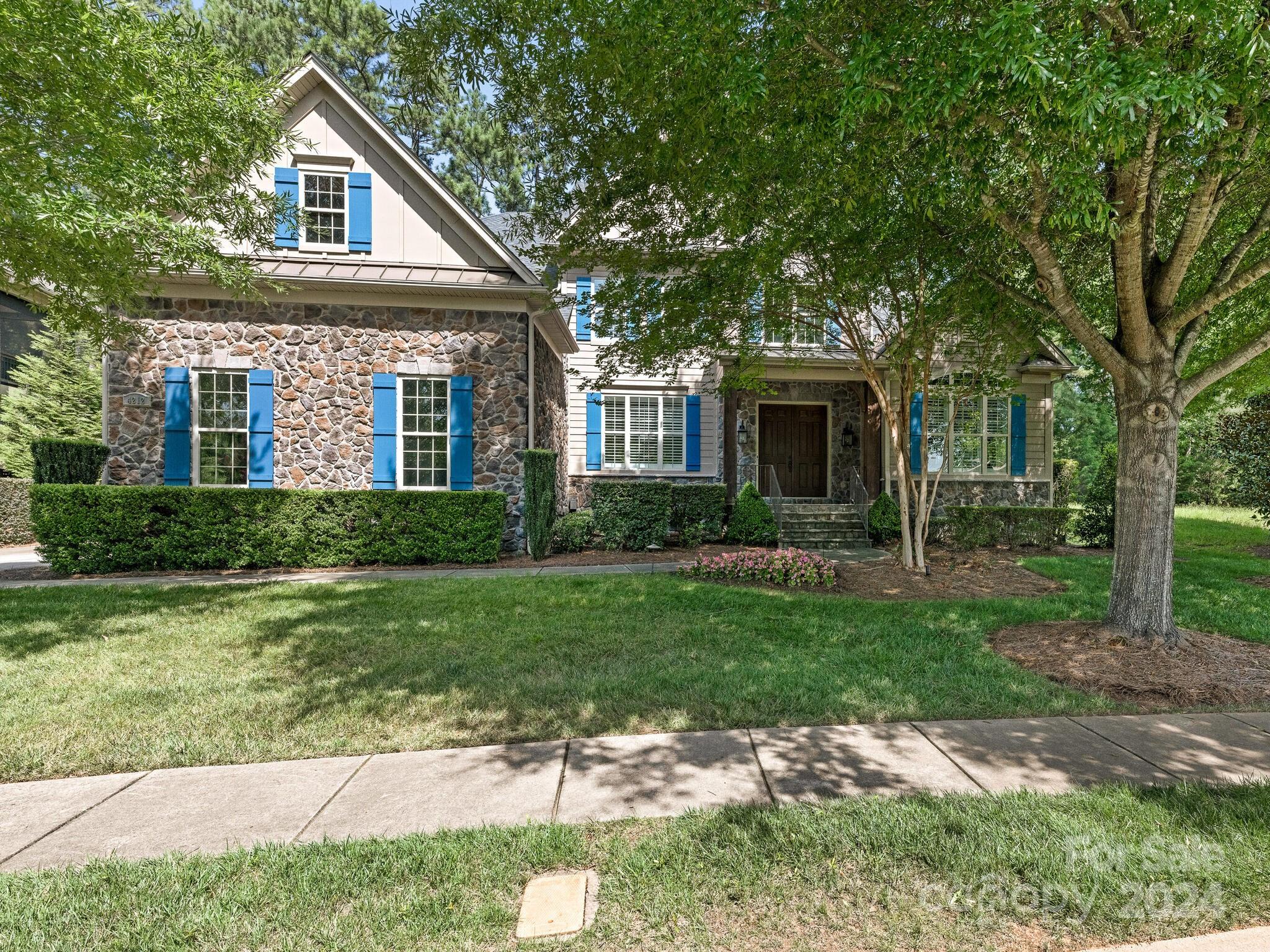 a front view of a house with a garden and yard