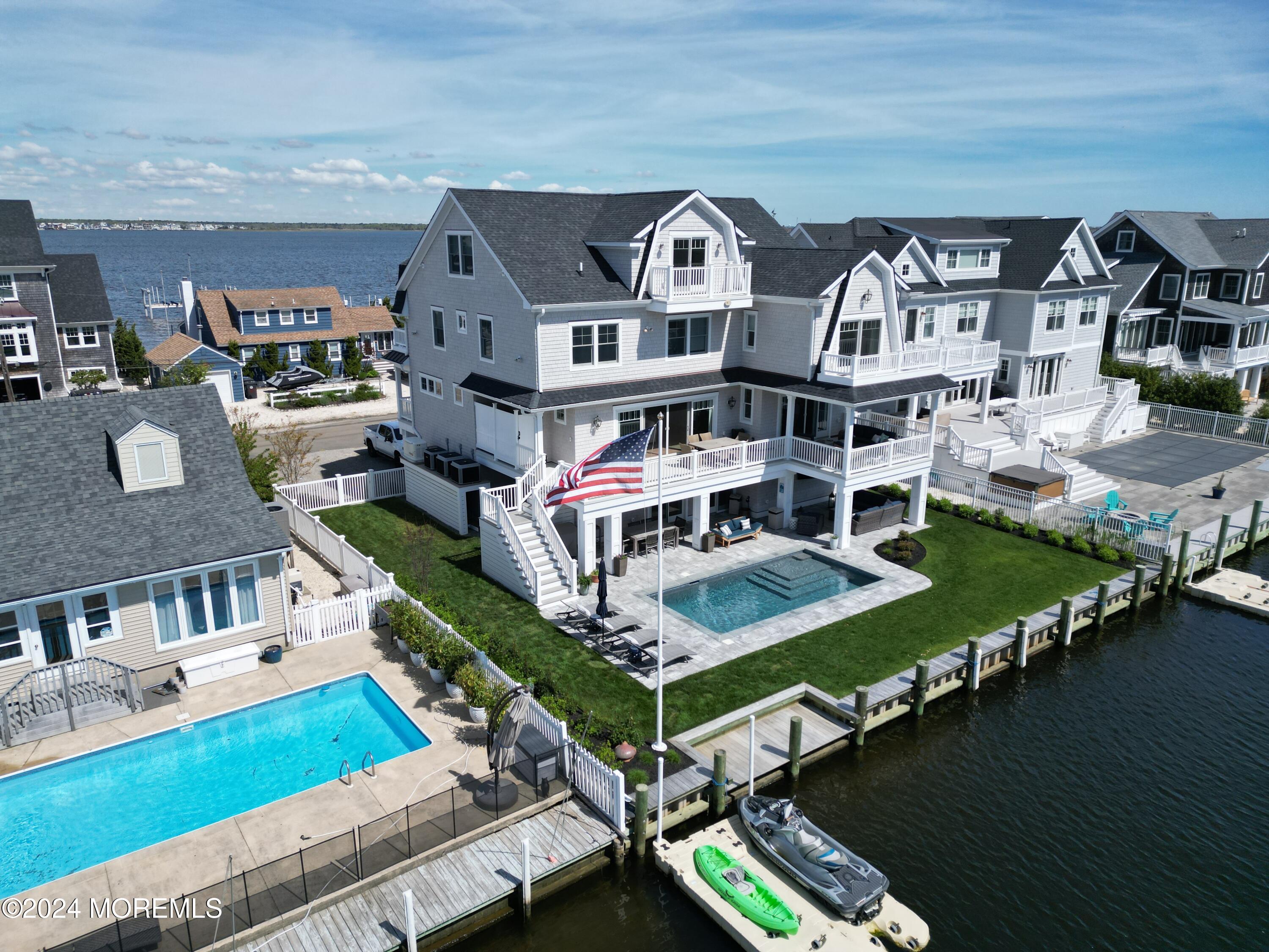 a view of a house with pool lawn chairs and floor to ceiling window