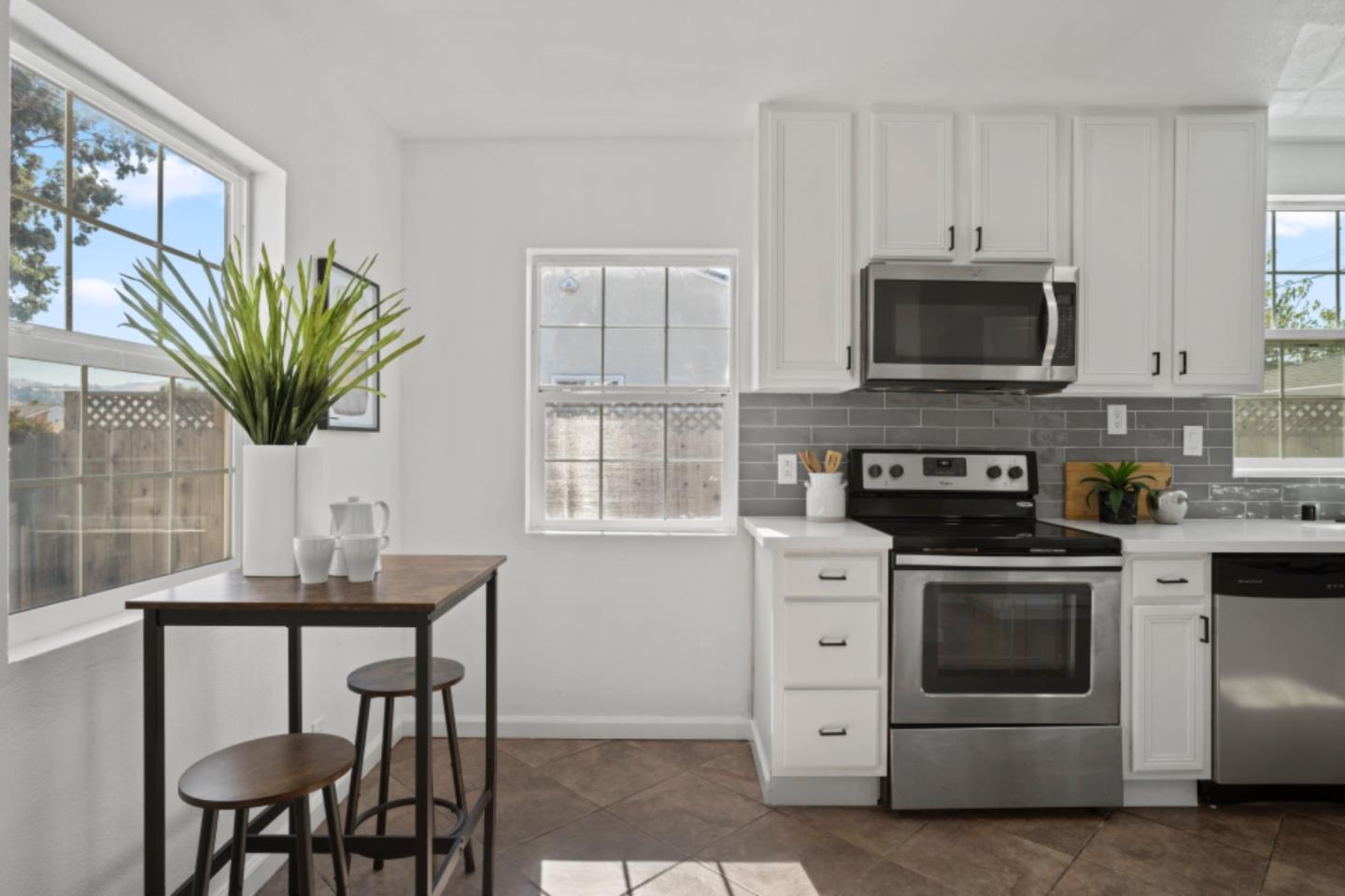 a kitchen with stainless steel appliances a stove a microwave sink and a window