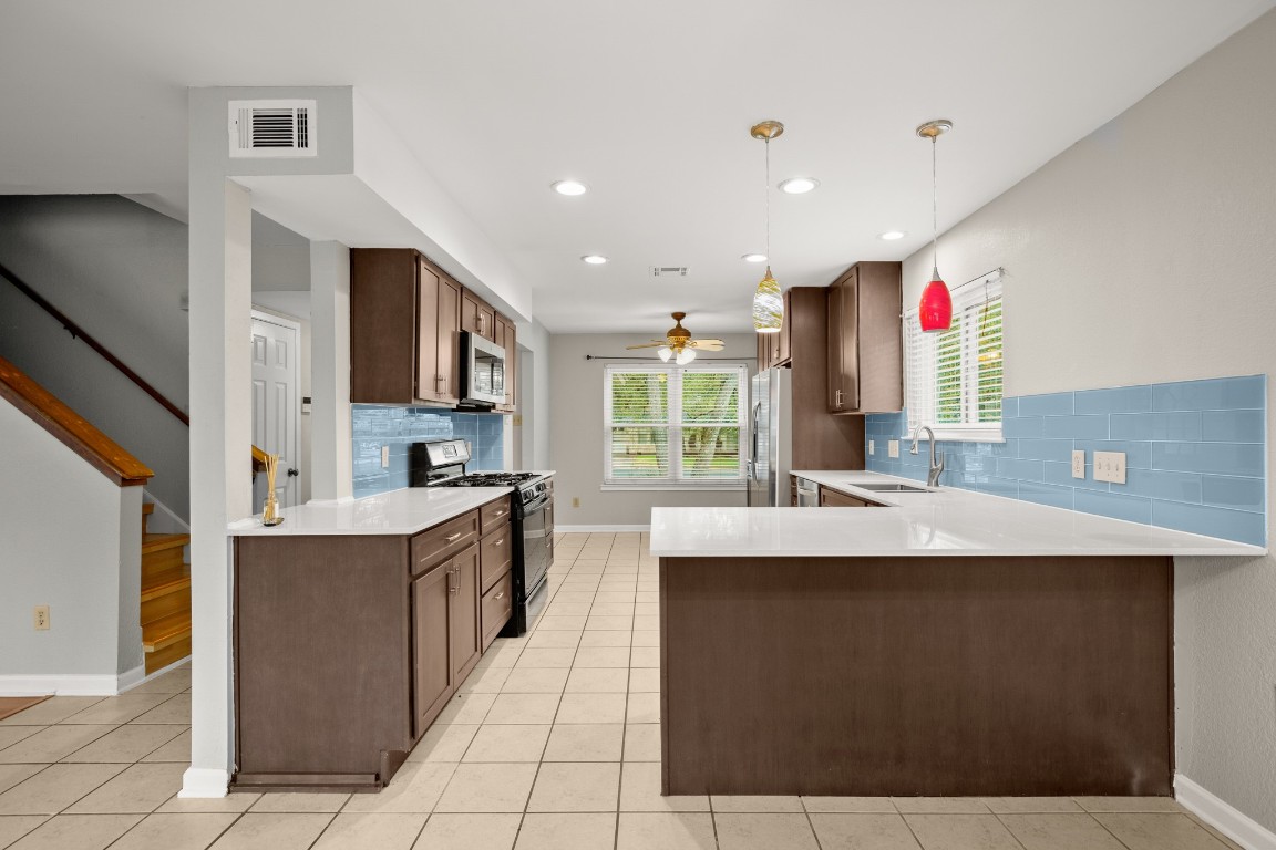 a kitchen with kitchen island stainless steel appliances a sink stove and cabinets