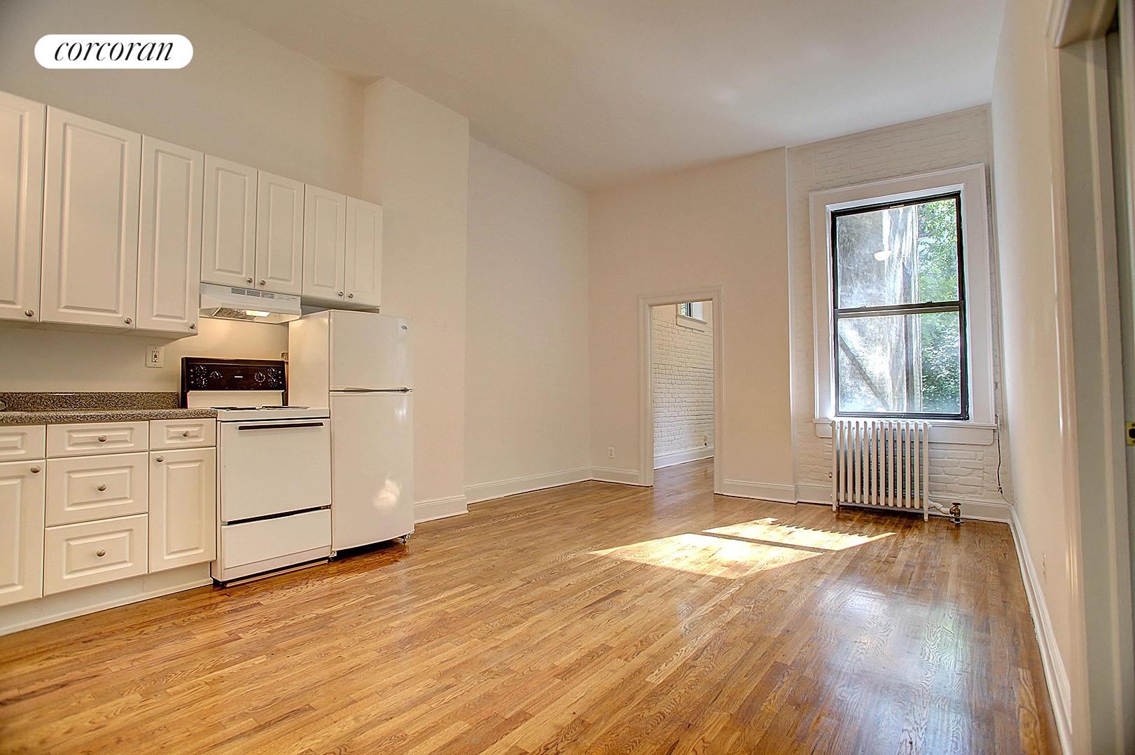 a view of a kitchen with wooden floor and electronic appliances