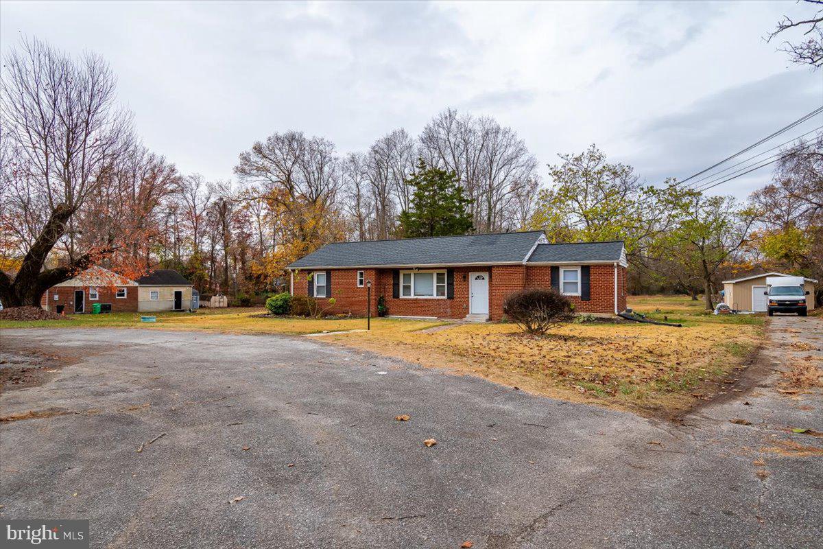 a front view of a house with a yard and trees