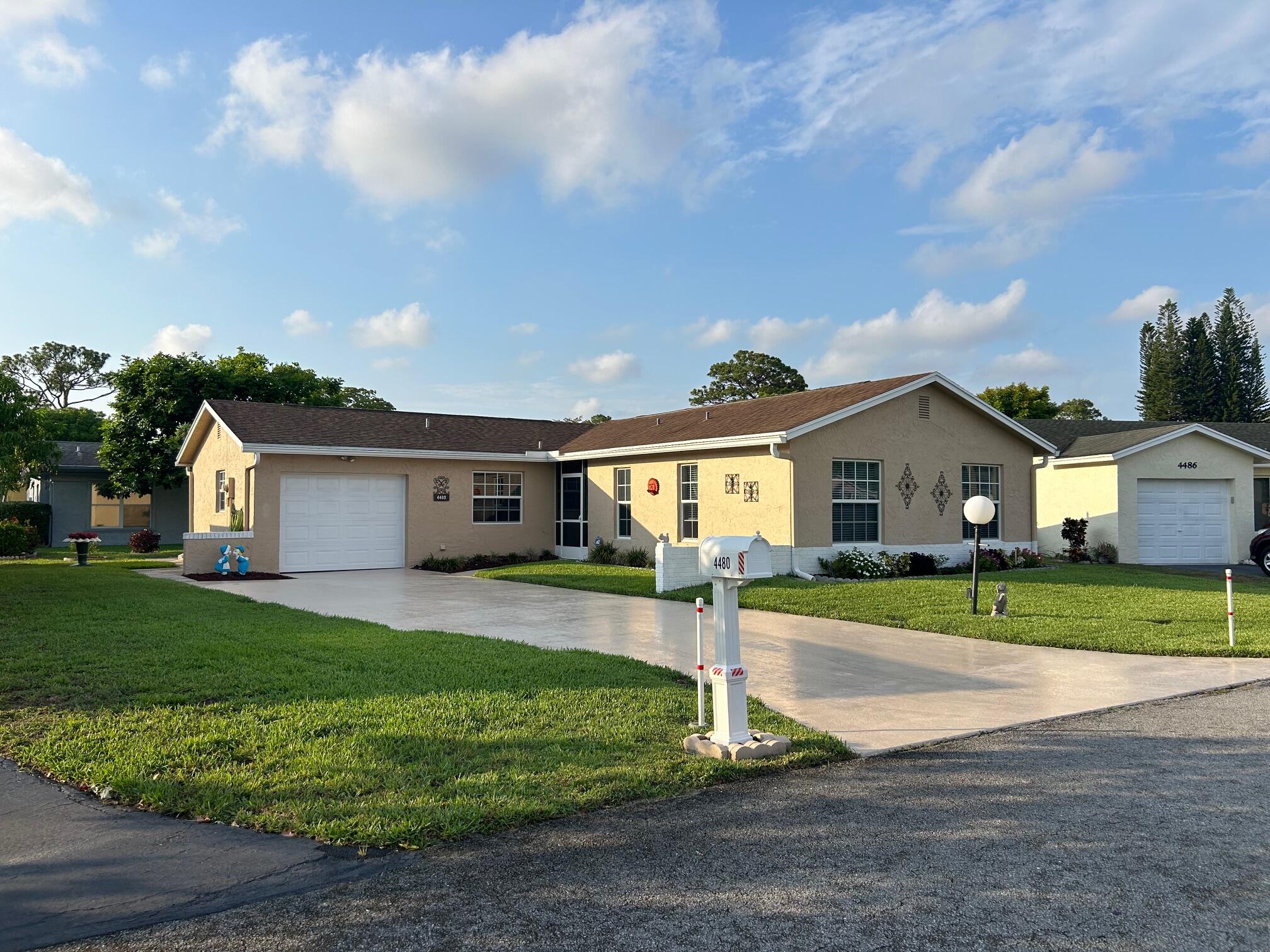 a front view of a house with a yard and trees