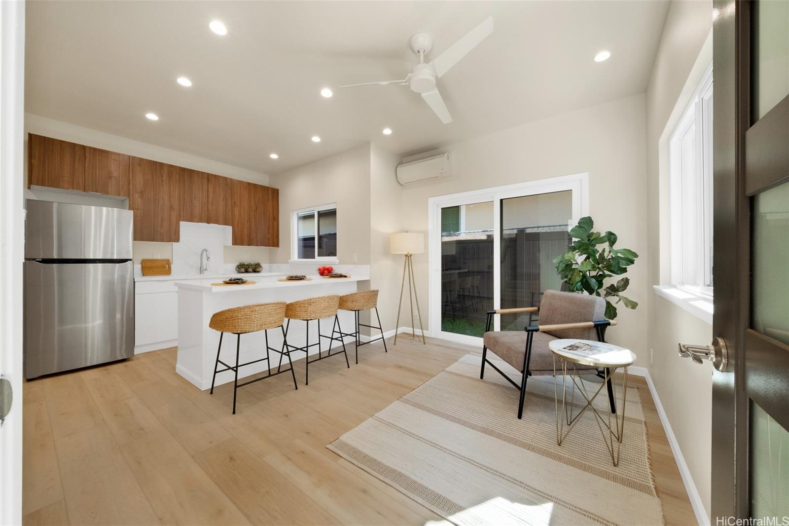 a living room with furniture wooden floor and a refrigerator