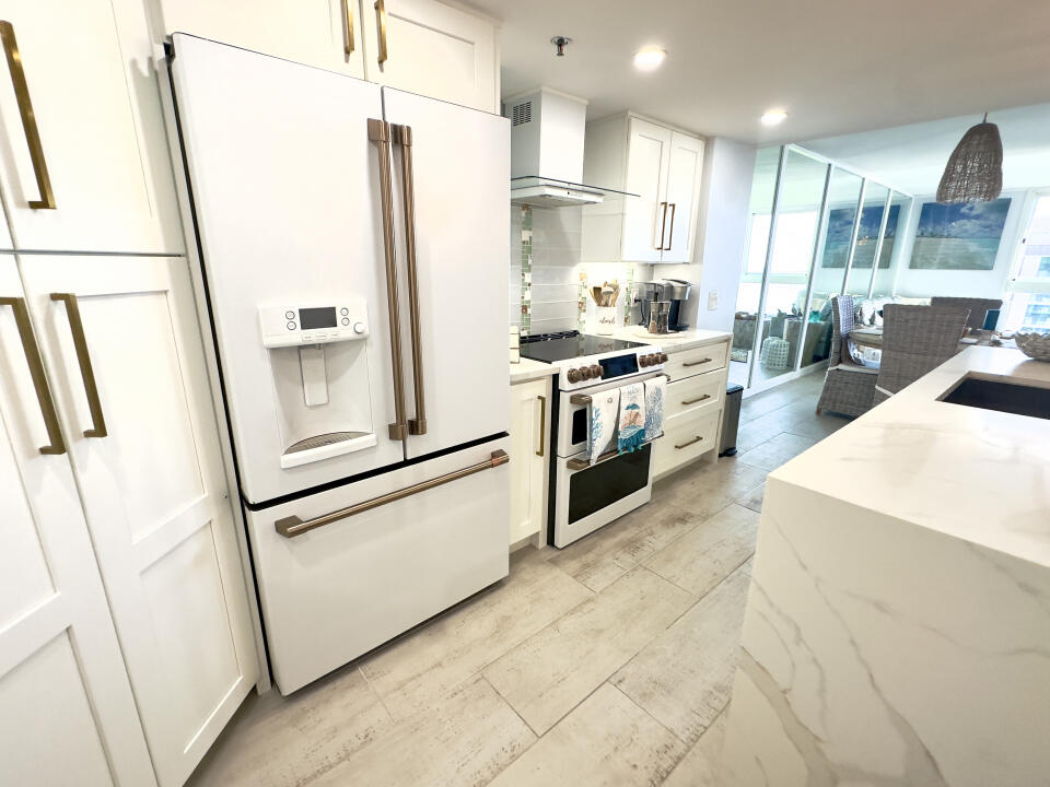 a kitchen with white cabinets and white appliances