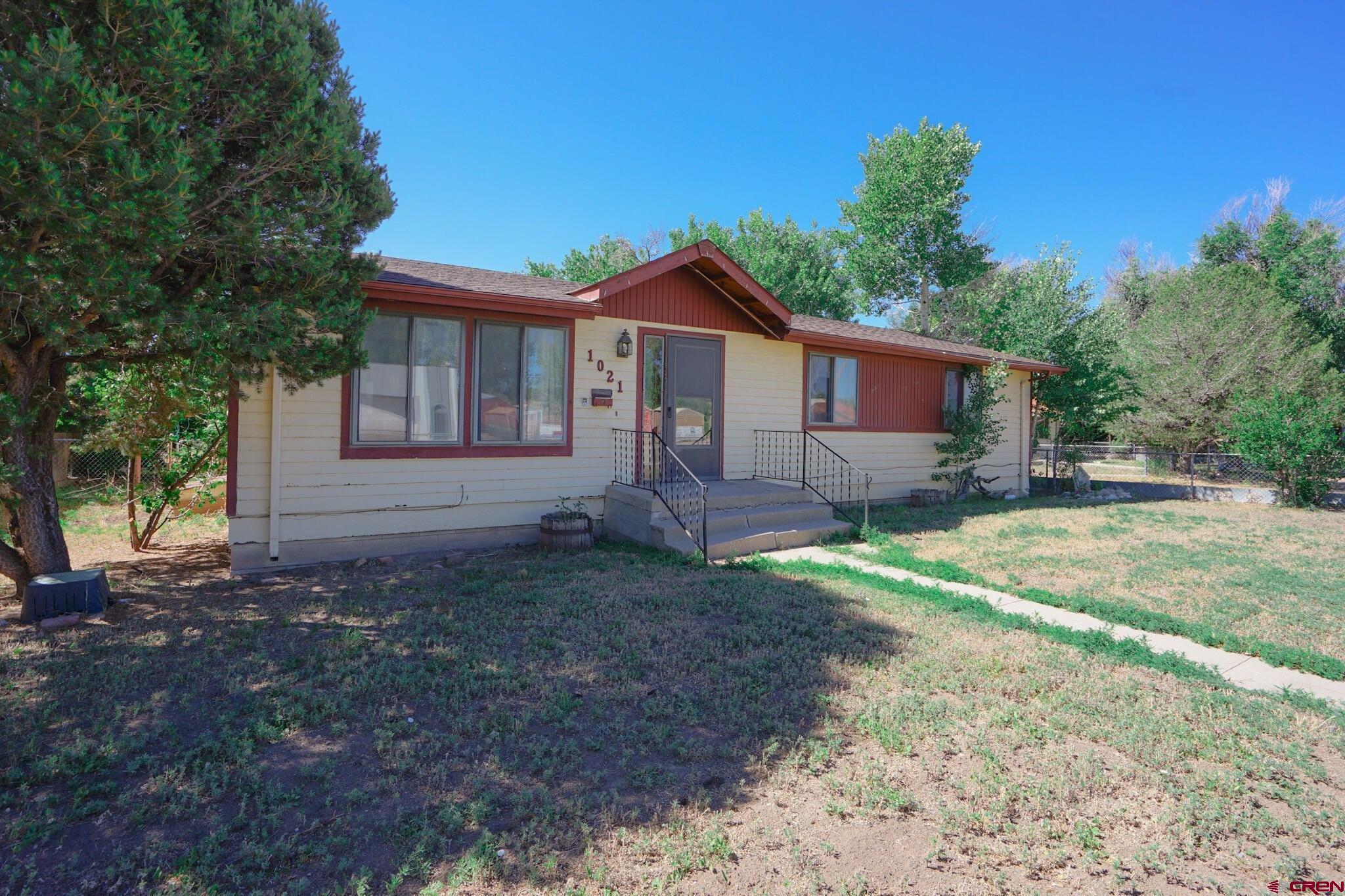 a view of a house with yard and a tree