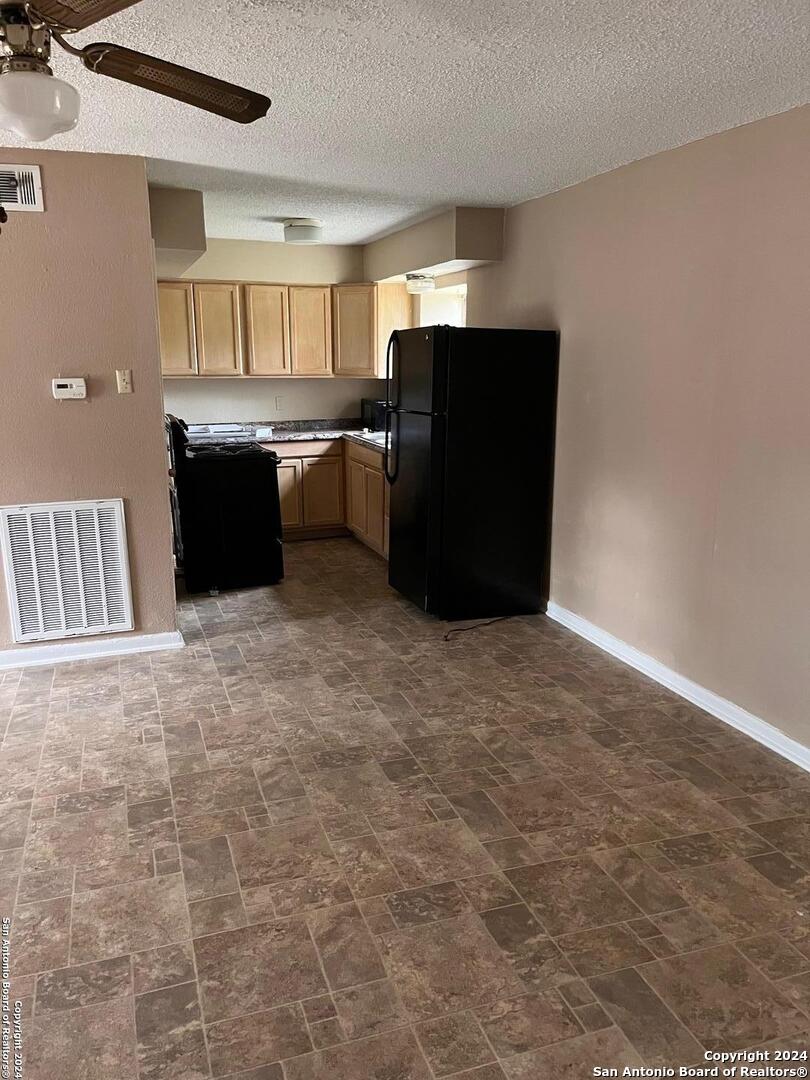 a kitchen with stainless steel appliances a refrigerator and a cabinets