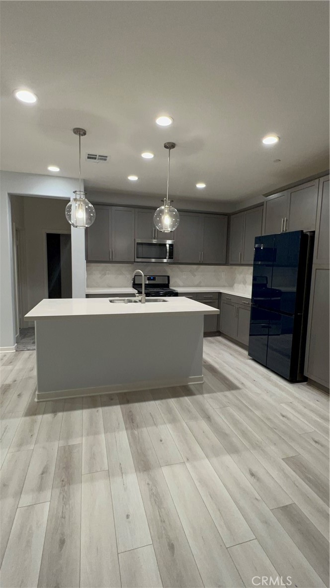 a large kitchen with stainless steel appliances a large counter top