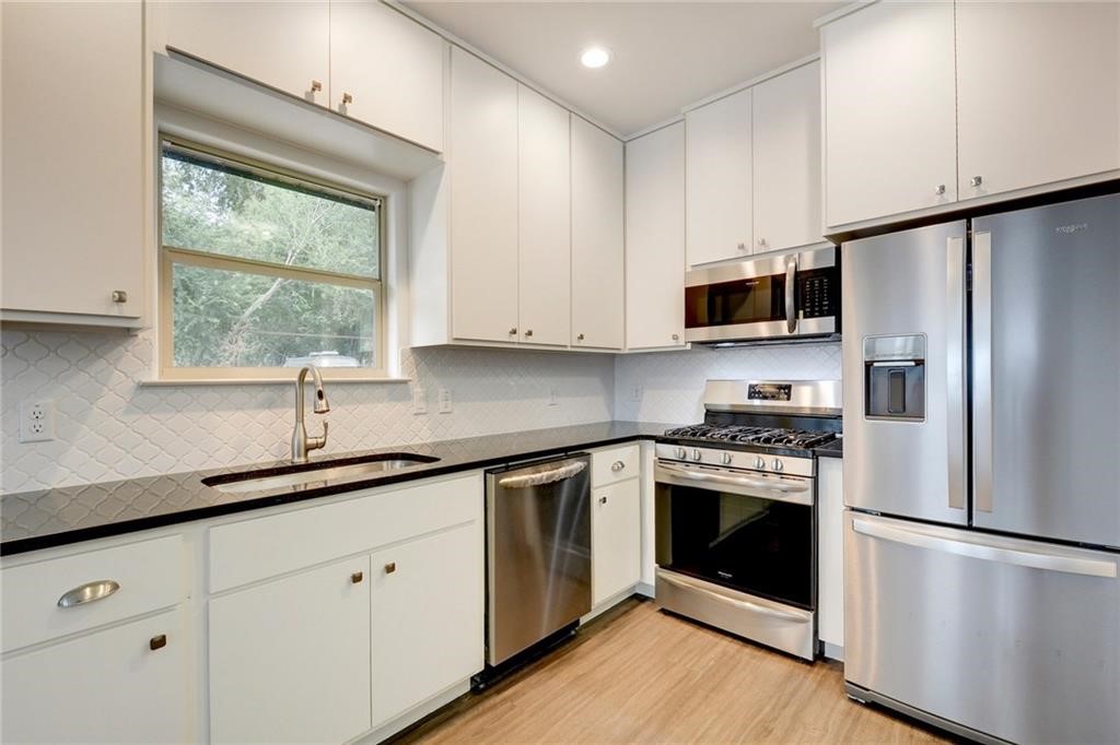 a kitchen with a white cabinets and a refrigerator