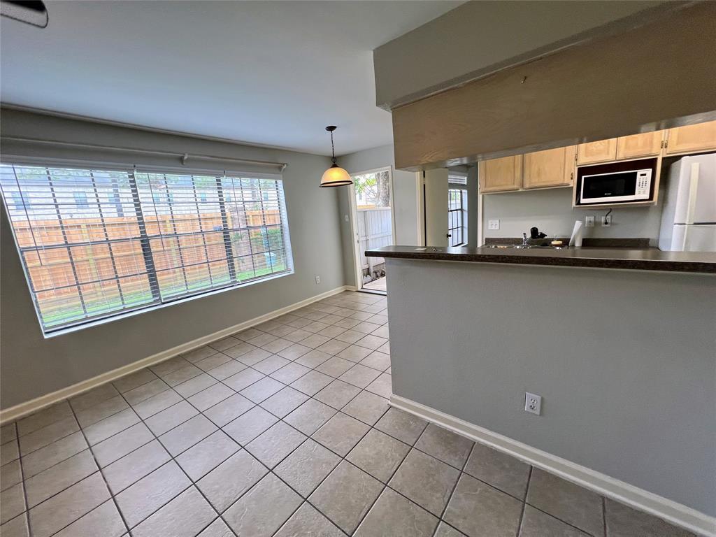 a view of kitchen with microwave and cabinets