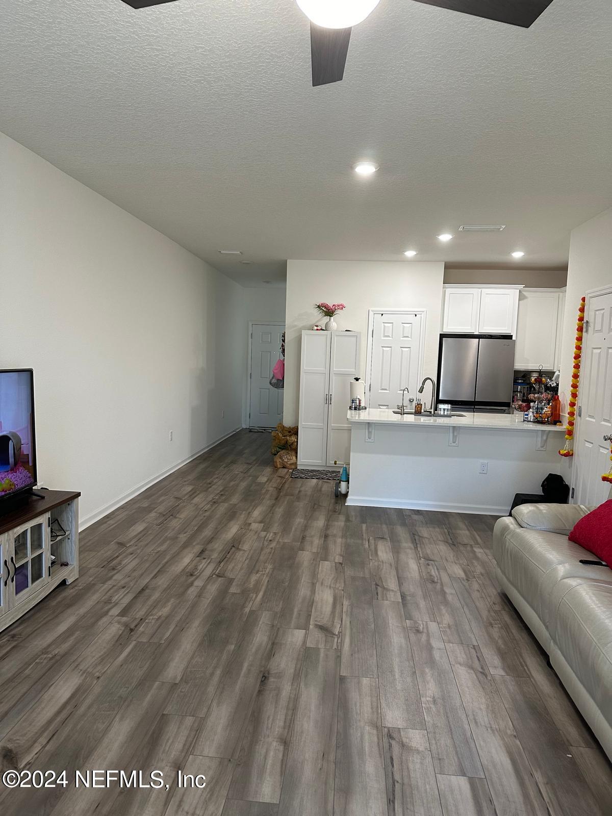 a view of kitchen with refrigerator sink and cabinets