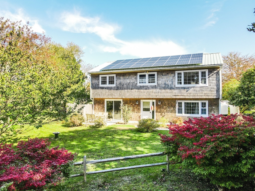 a front view of a house with a yard and potted plants