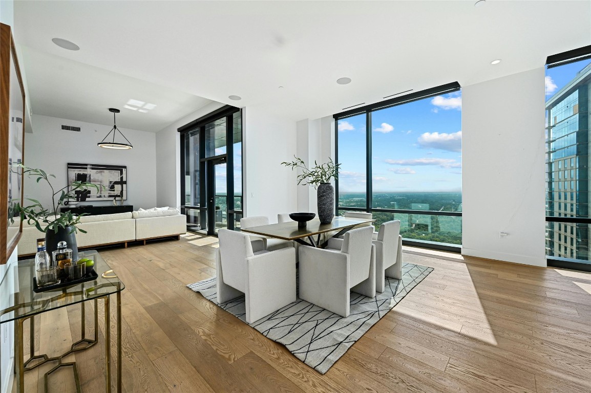 a living room with furniture a large window wooden floor and a rug