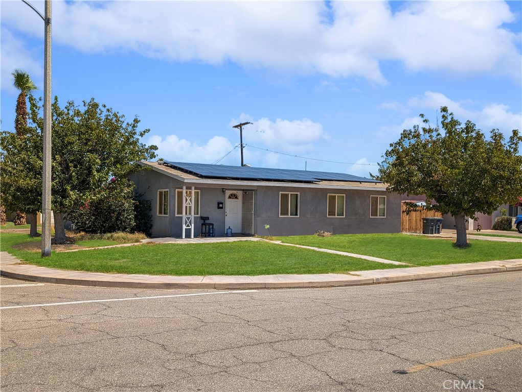 a front view of a house with a yard and trees