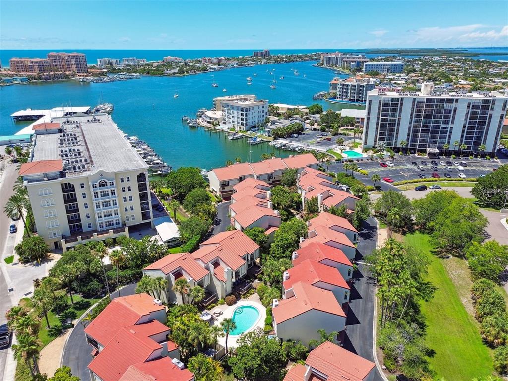 an aerial view of ocean and residential houses with outdoor space