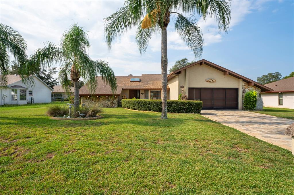 a view of a house with a yard and palm trees