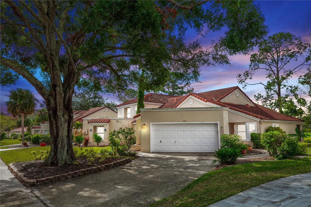 a front view of a house with a yard and tree s