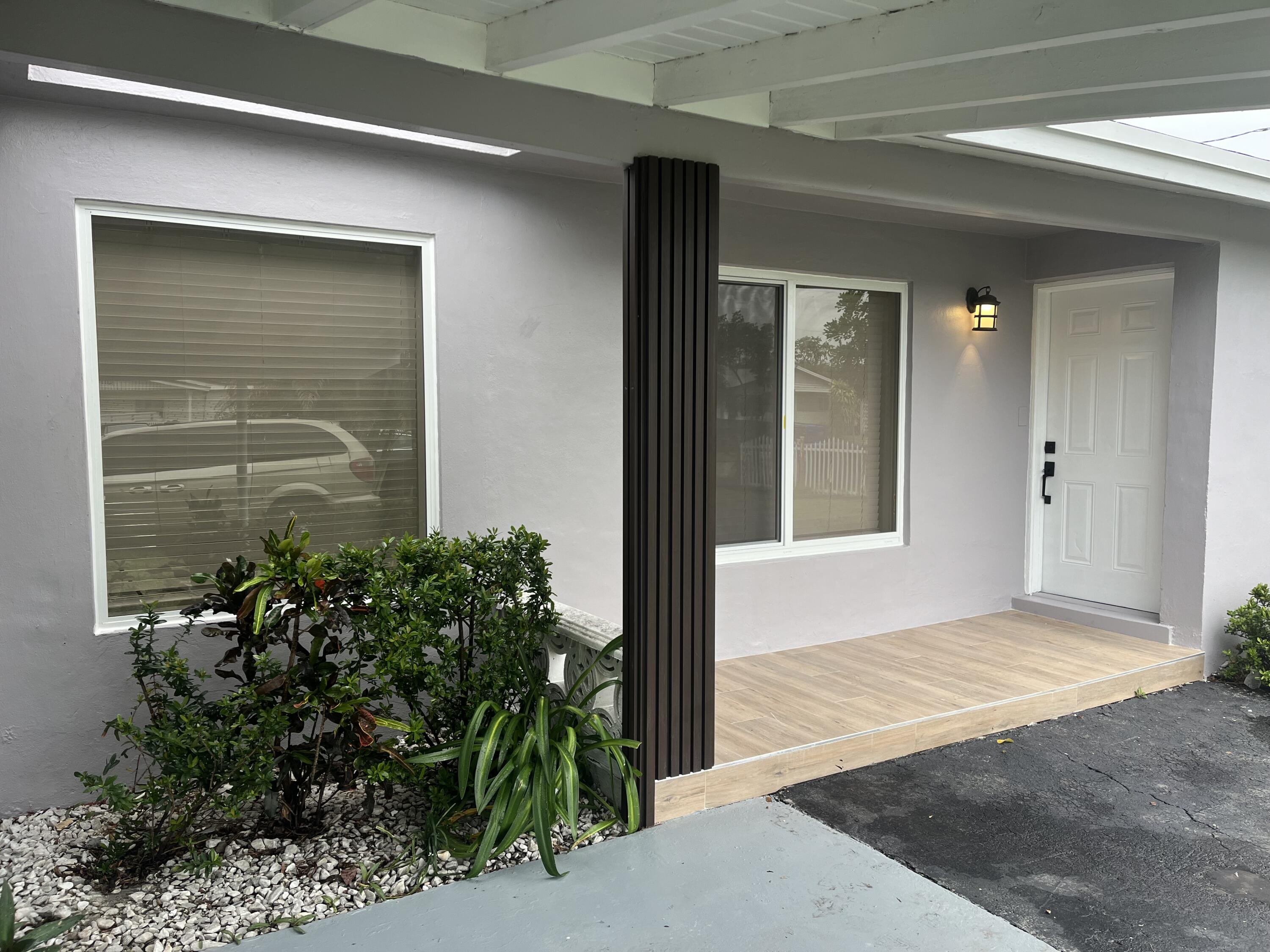 a front view of a house with plants