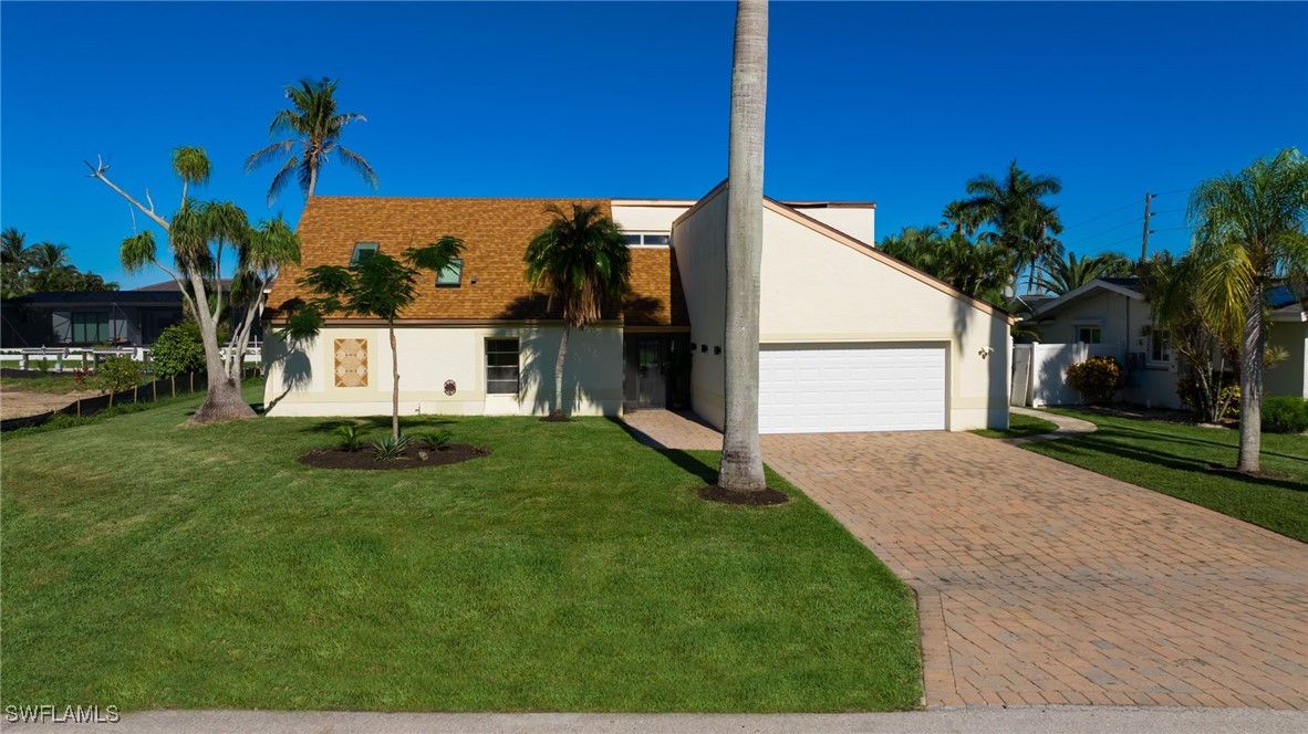 a view of a house with backyard and a tree