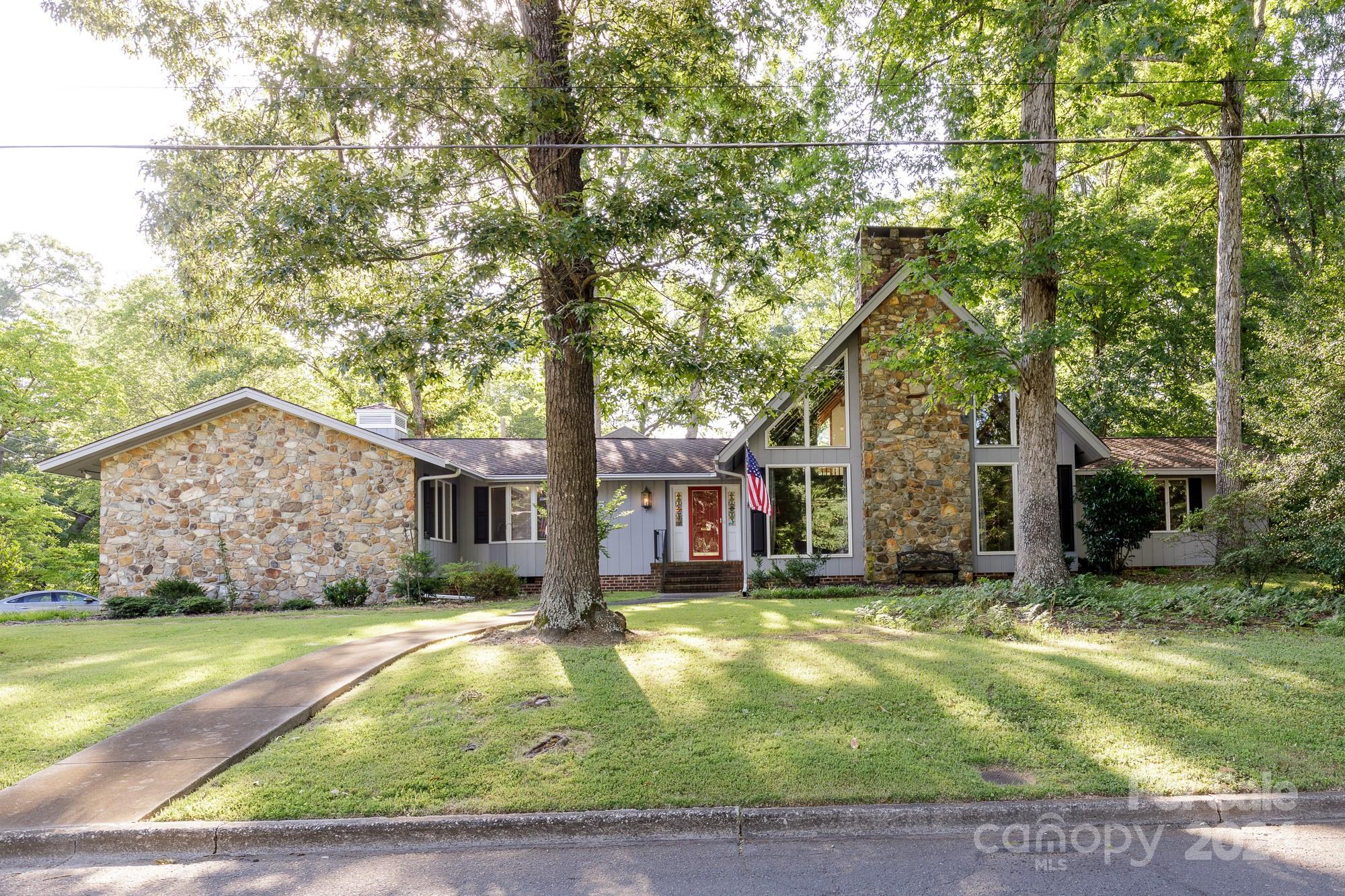 a front view of house with yard and trees around