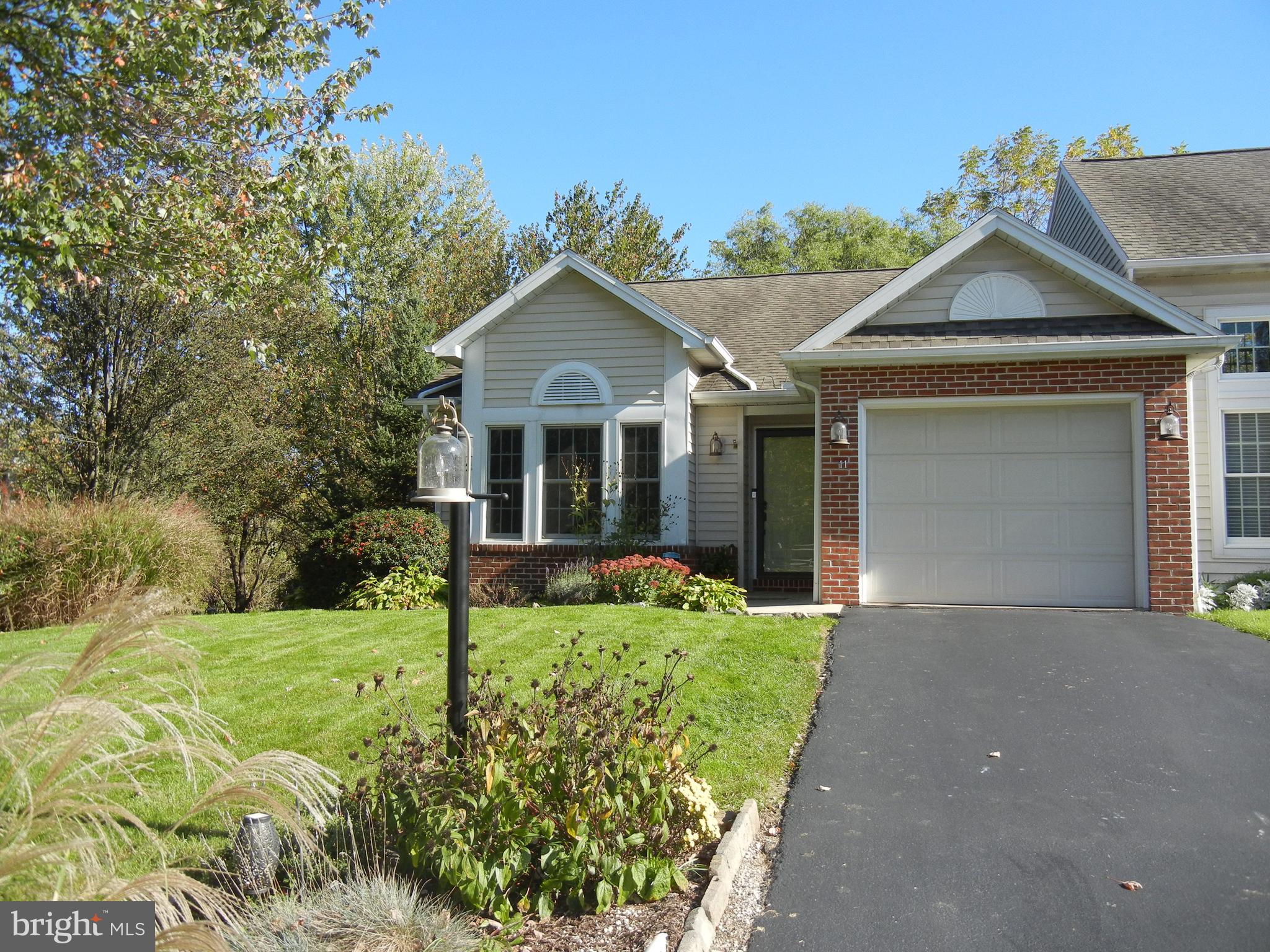 a front view of a house with yard and green space