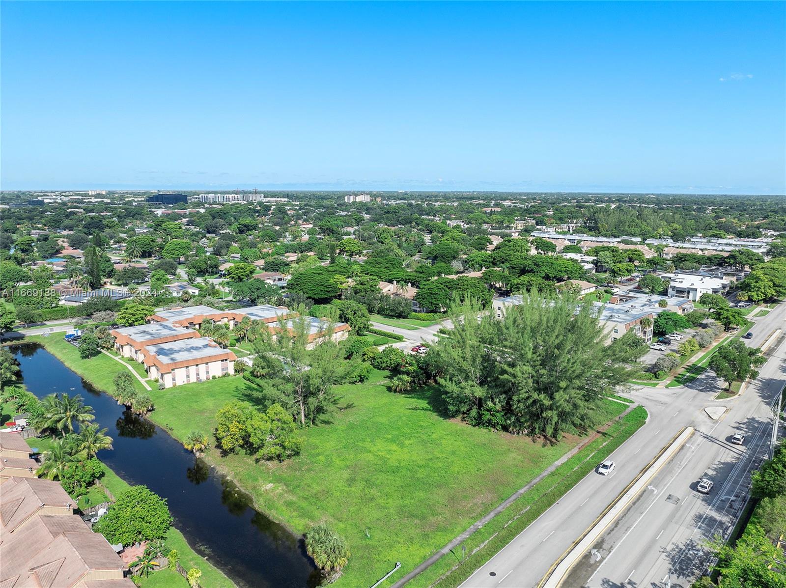 an aerial view of residential houses with outdoor space and trees