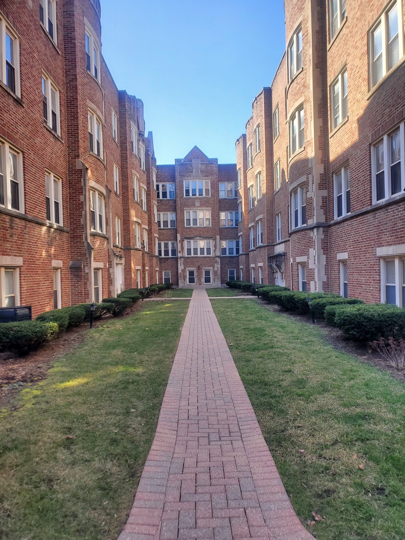 a view of a brick house next to a yard