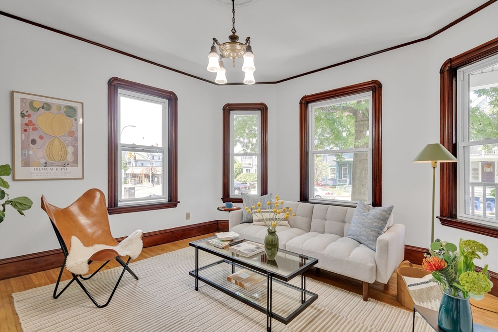 a living room with furniture a chandelier and a window