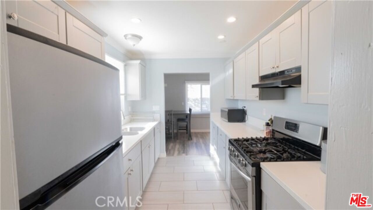 a kitchen with a sink a stove and cabinets