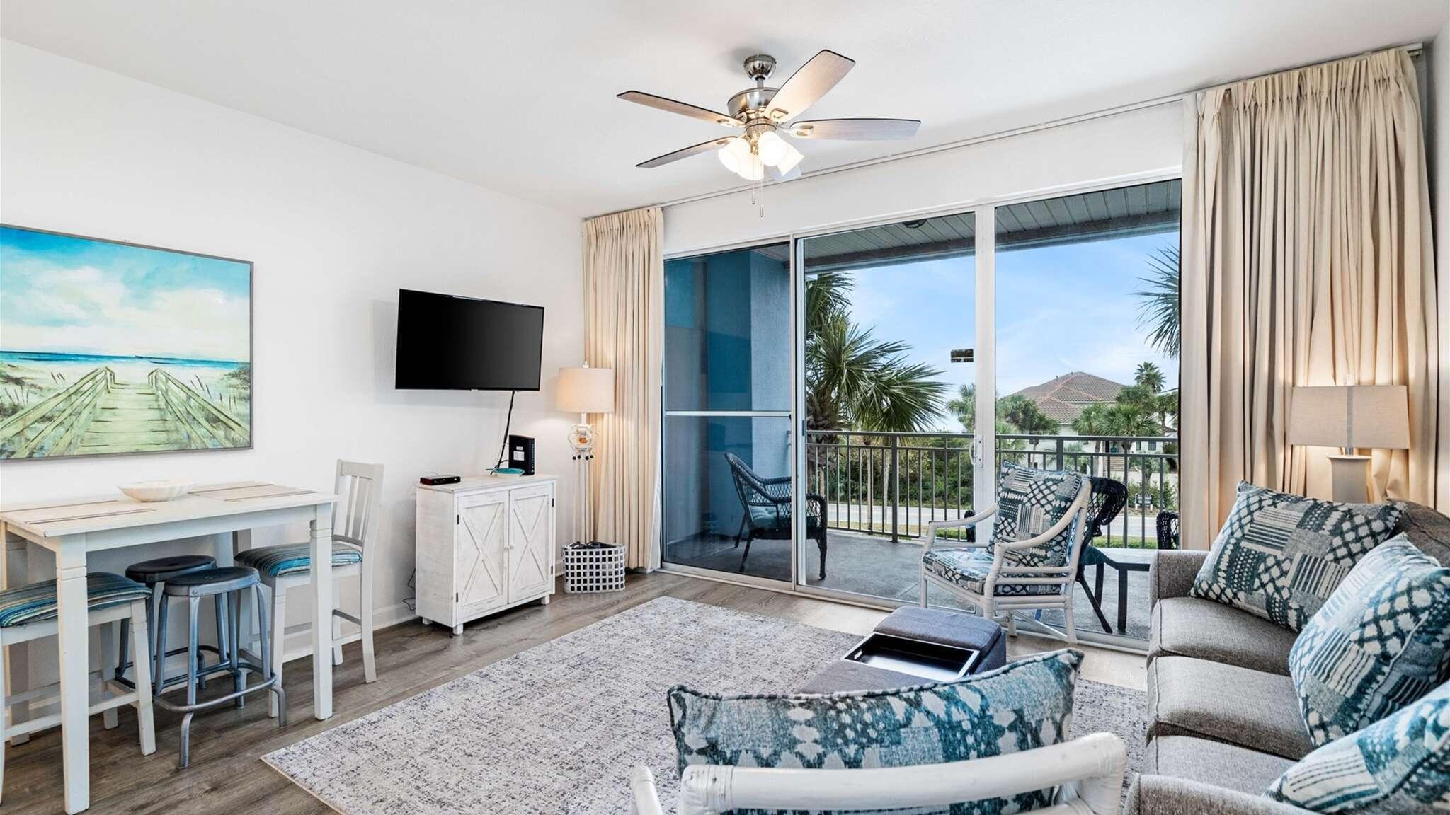 a living room with furniture a flat screen tv and a large window