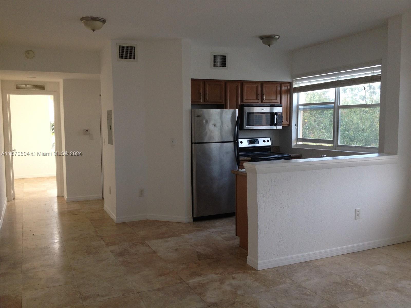 a kitchen with stainless steel appliances a refrigerator and a stove top oven