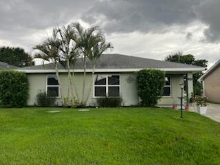 a front view of a house with a garden and yard