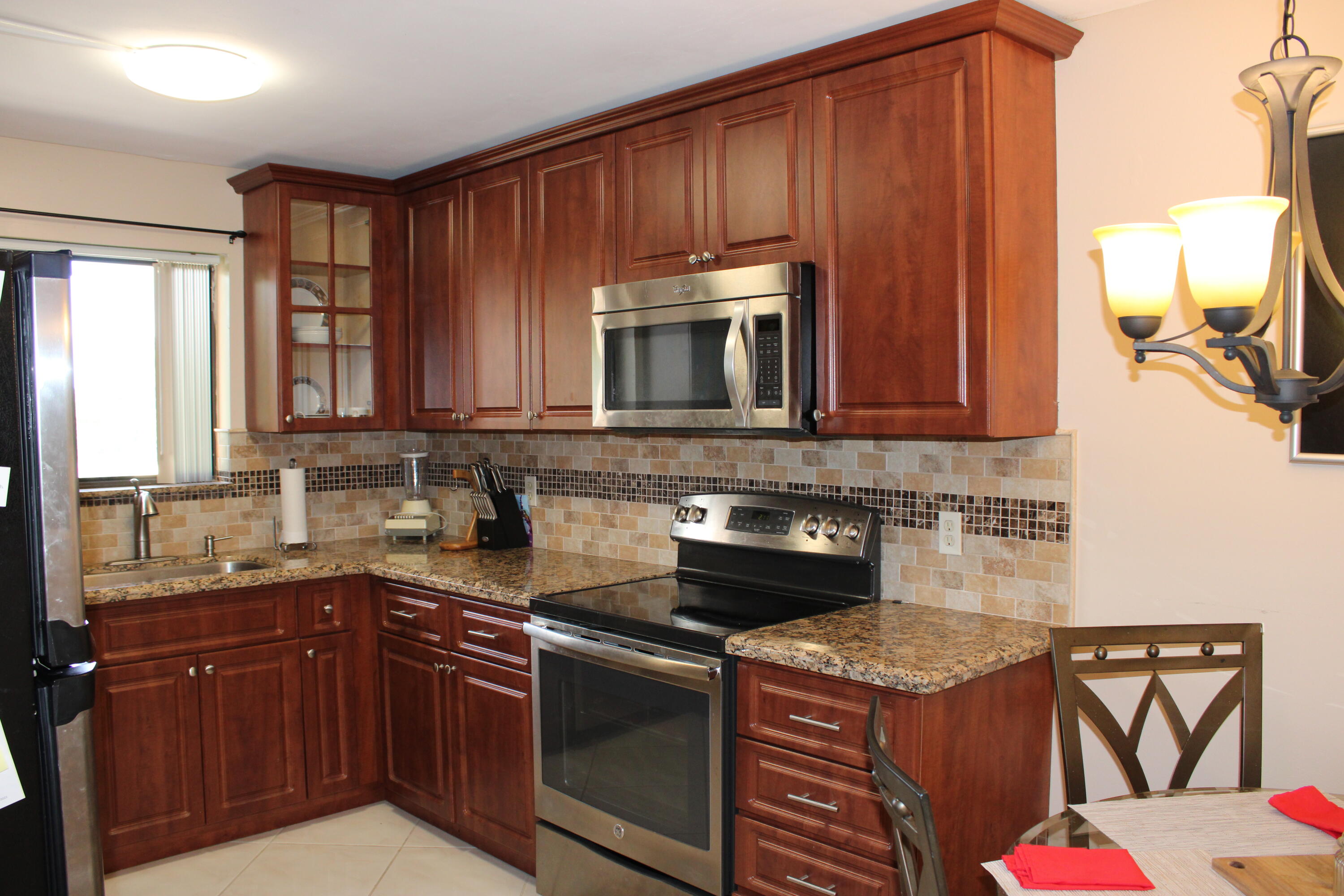 a kitchen with stainless steel appliances granite countertop a stove a sink and a microwave