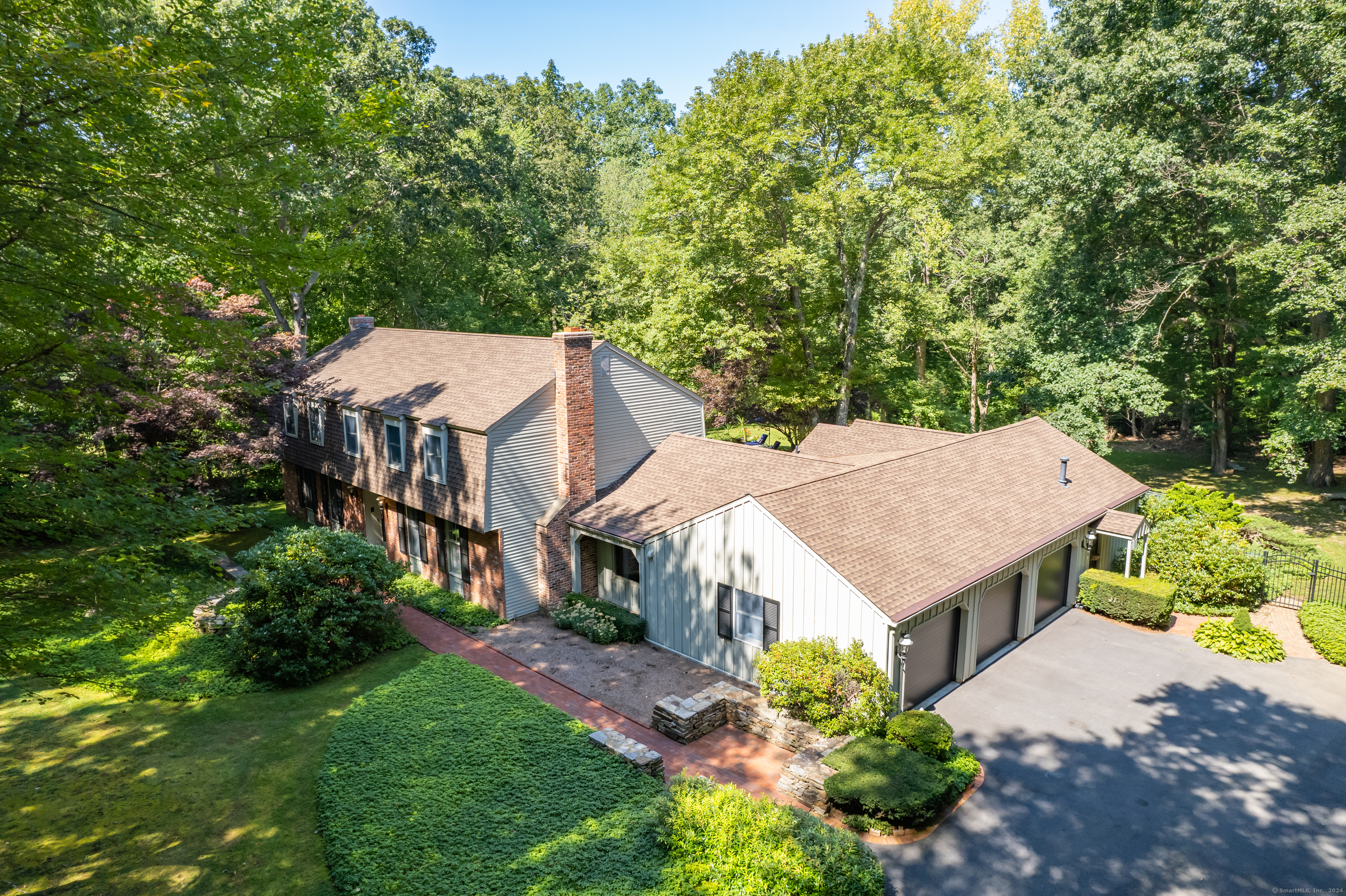 an aerial view of a house with yard and large trees