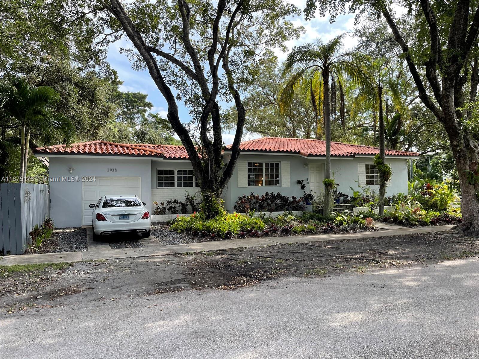 a front view of a house with a garden and plants