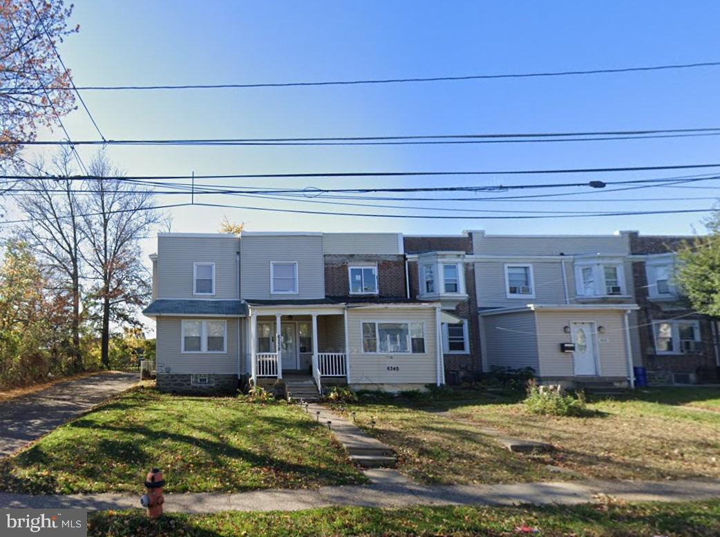 a view of a brick house with a yard in front of it