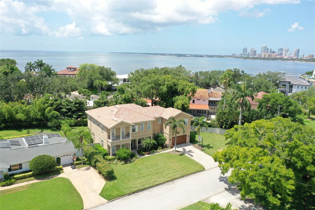 aerial view of a house with a yard and lake view