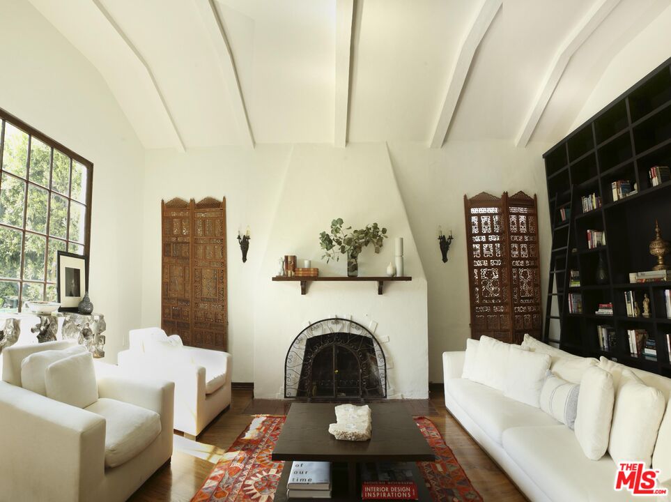 a living room with furniture a fireplace and a large window