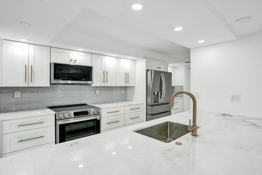 a kitchen with kitchen island a stove and a microwave