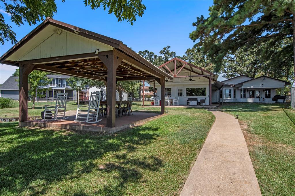 a porch with a table and chairs under an umbrella