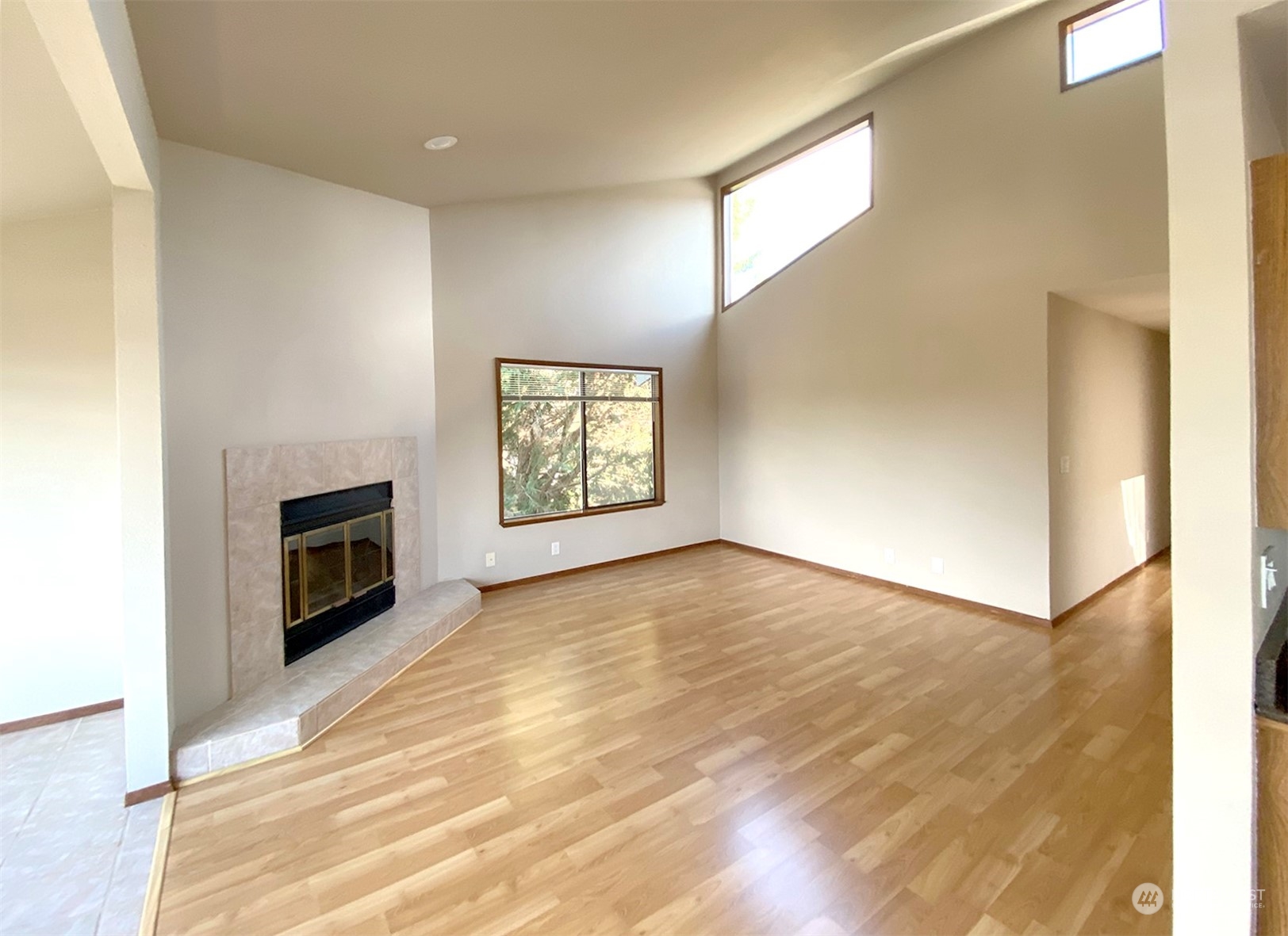 a view of a livingroom with wooden floor and a fireplace