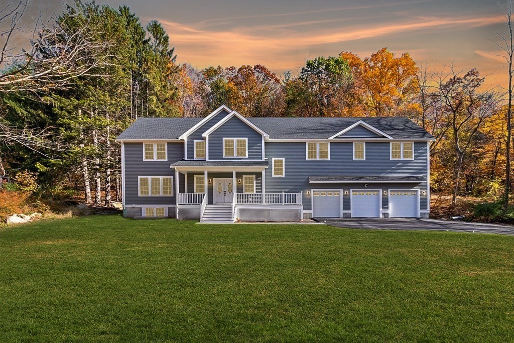 a view of a house with a big yard and large trees