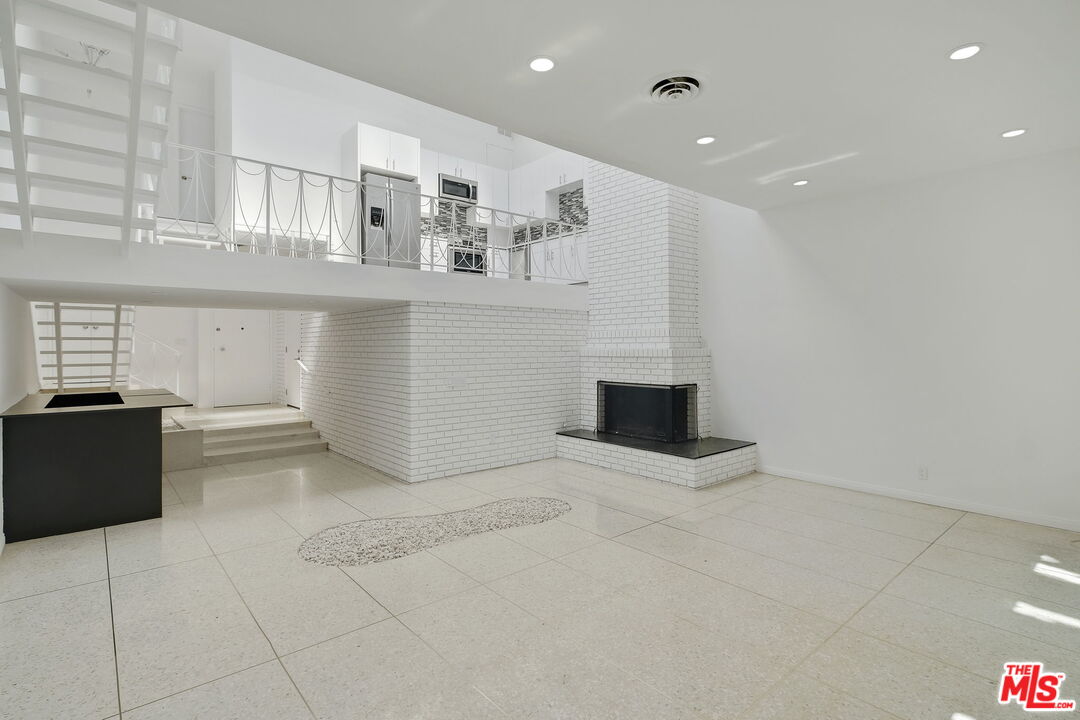 a view of kitchen with stainless steel appliances cabinets and empty room