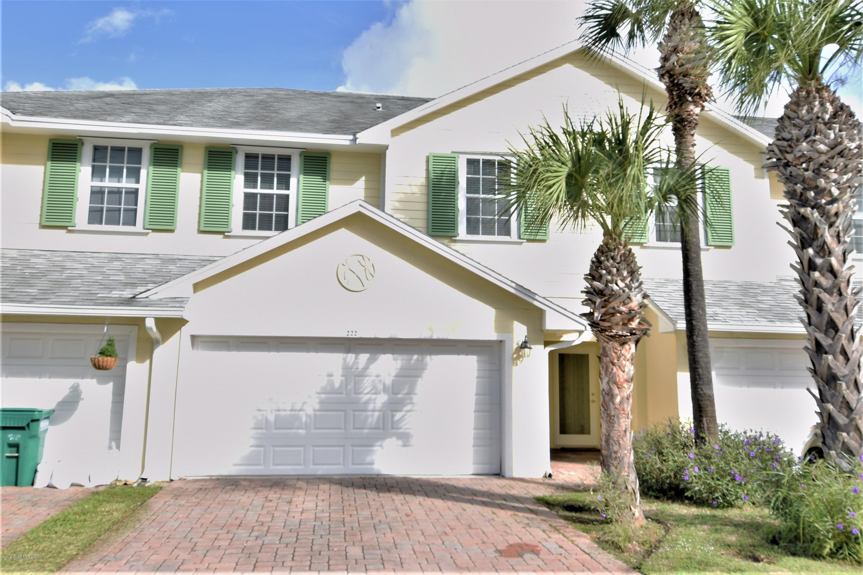 a view of a house with a yard and palm trees