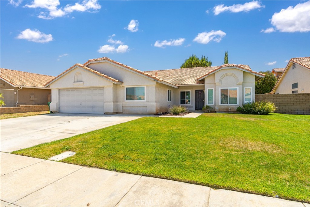 a front view of a house with a garden and yard