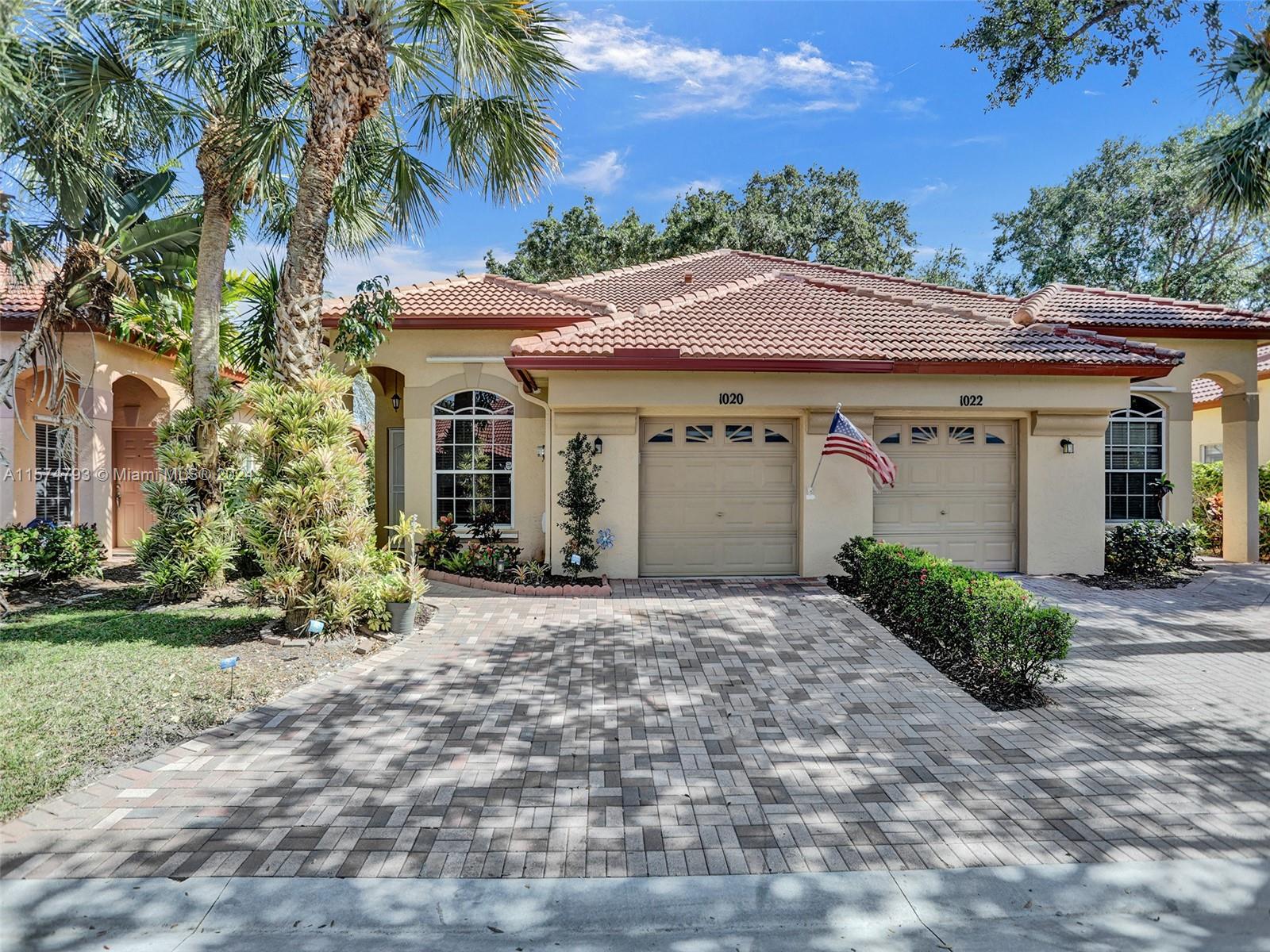 a front view of a house with a yard and a garage