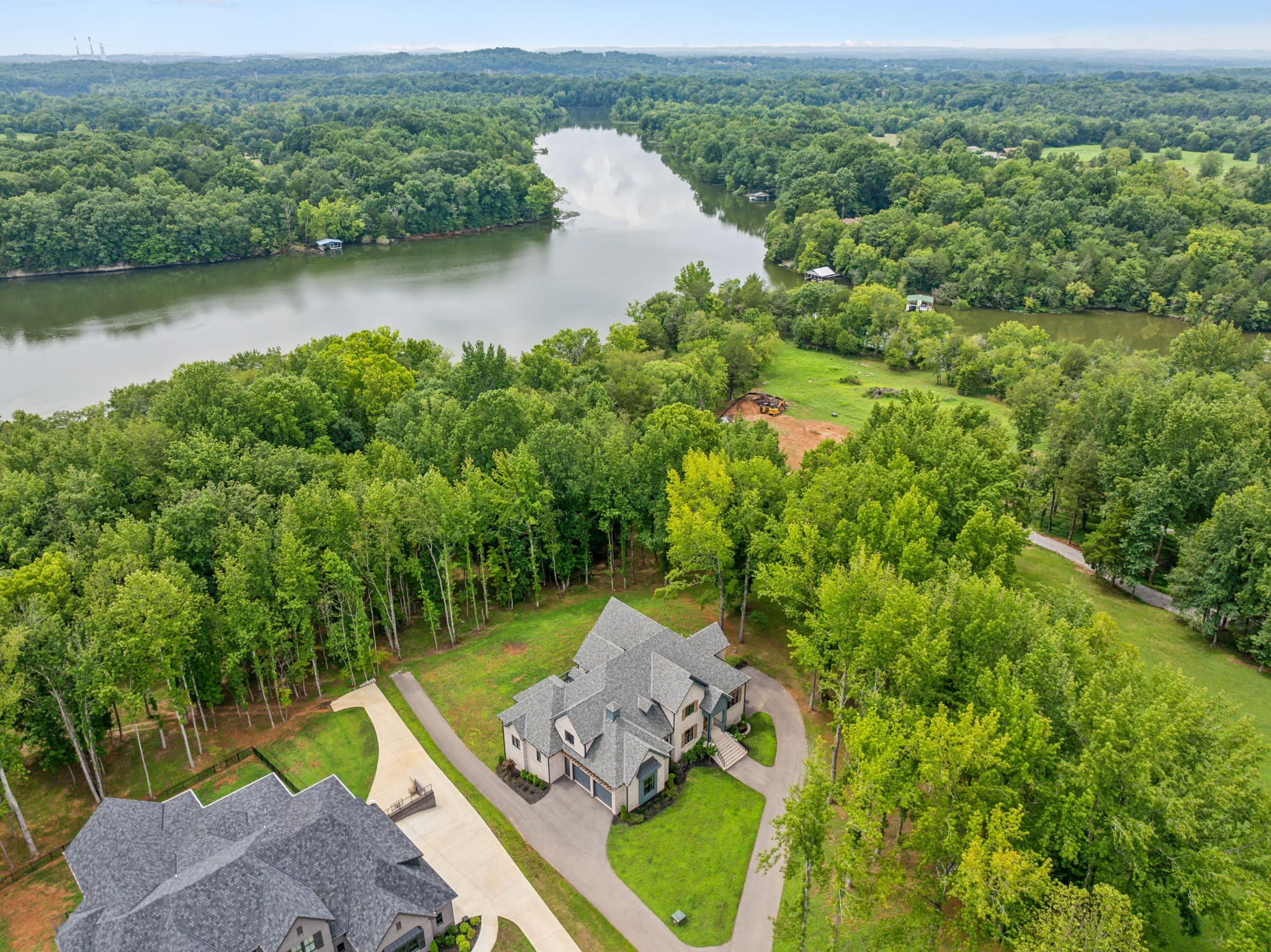 an aerial view of a house with a yard and lake view