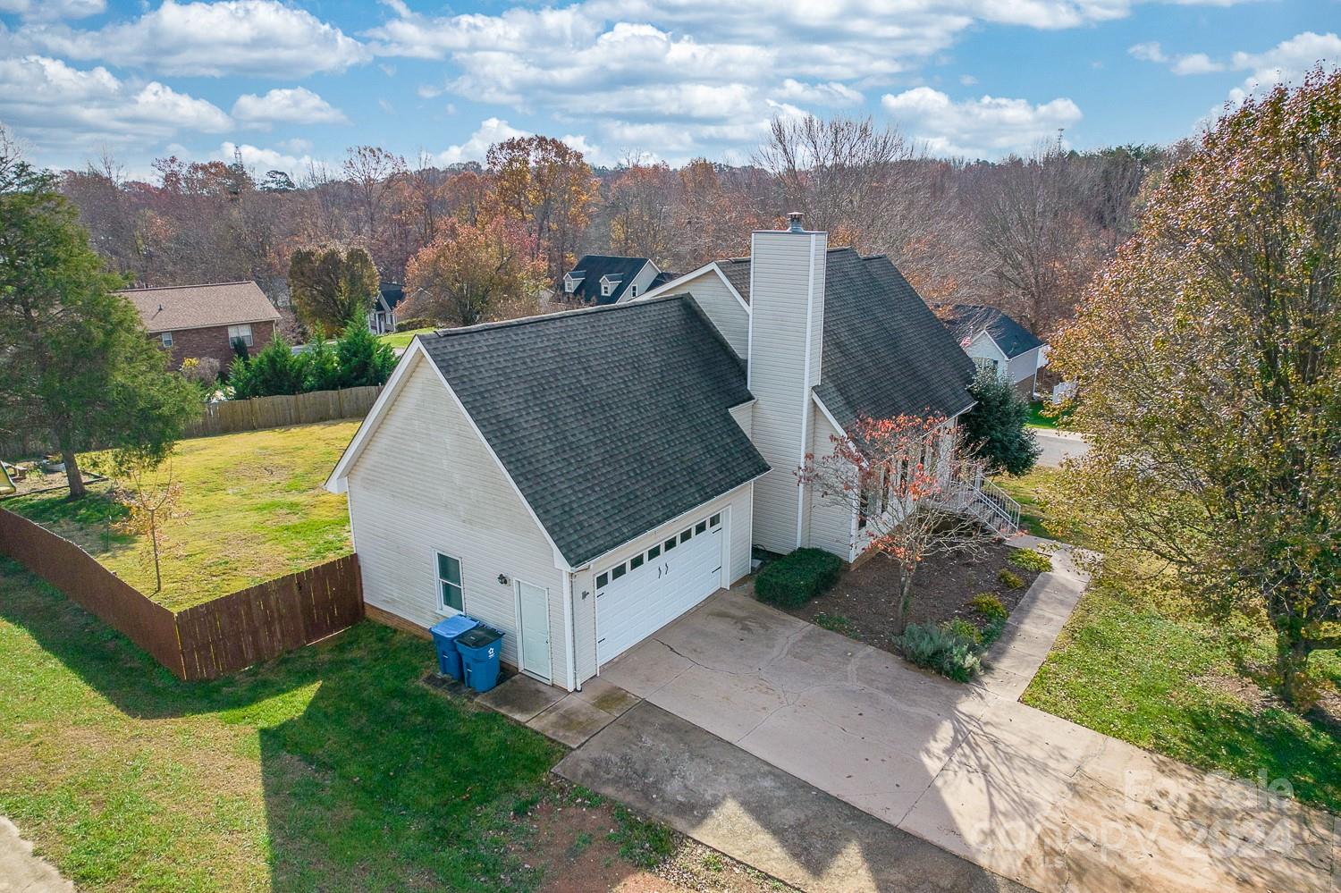 an aerial view of a house with a yard and large trees