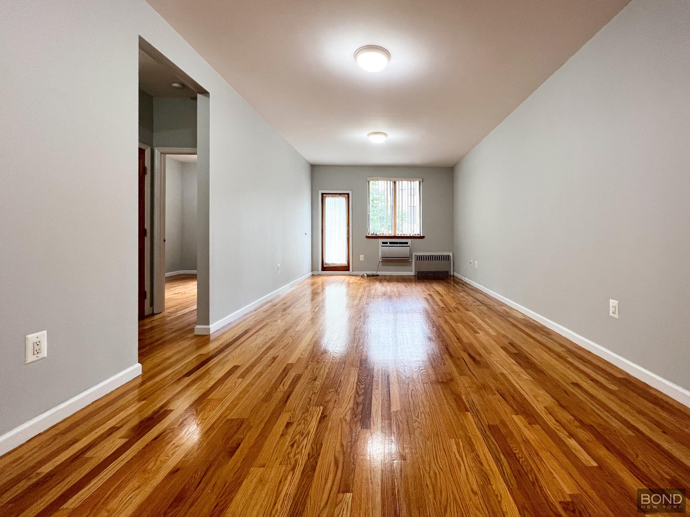 a view of a room with wooden floor and window