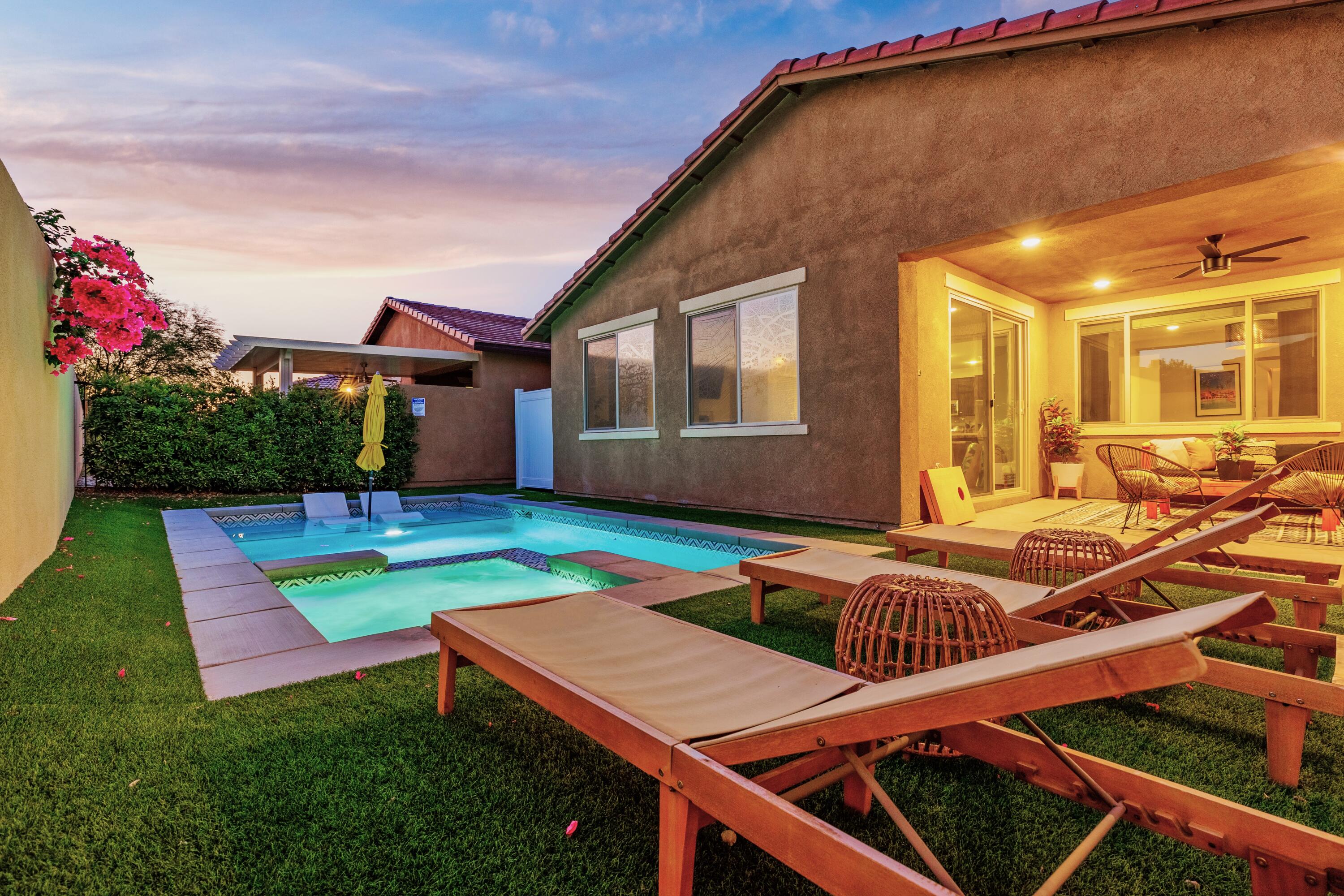 a view of a house with pool and chairs